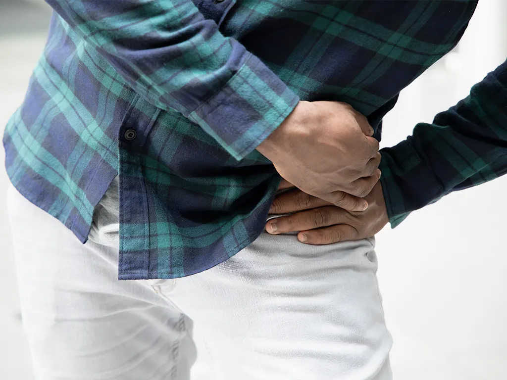 Man holding hip suffering with pelvic pain