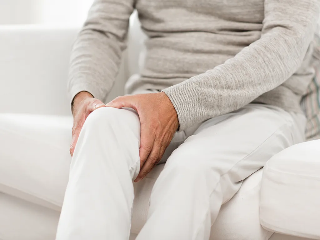 Woman holding knee with post-operative pain