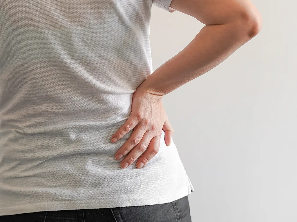 woman holding her back with sciatica